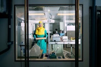 a person in a protective suit standing in a laboratory