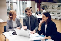 a group of business people sitting around a table in an office