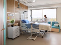 a hospital room with a nurse standing in front of a bed